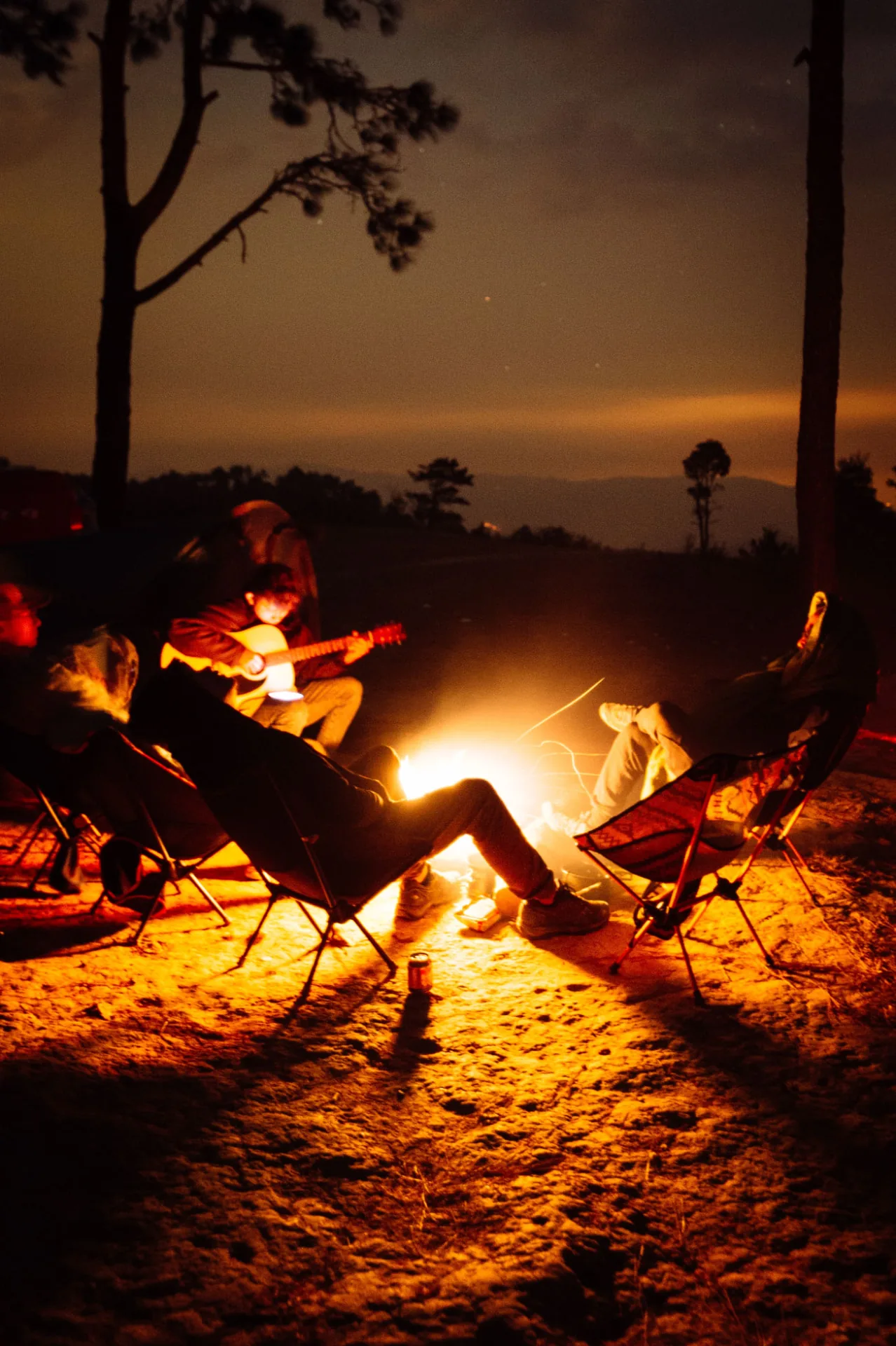 Club members relaxing by guitar and campfire at MOC27